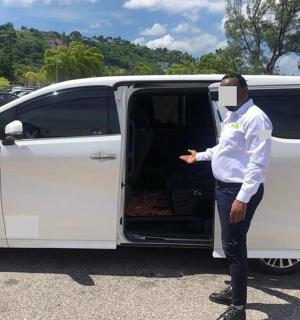 一名戴着口罩的男子站在一辆货车旁边