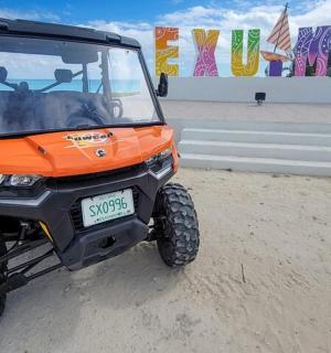 oranžová čtyřkolka zaparkovaná na prašném poli