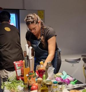 a woman standing in a kitchen preparing food