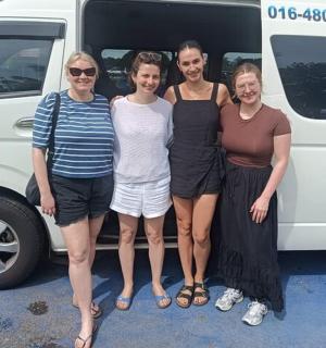 مجموعة من الأشخاص يقفون أمام شاحنة صغيرة