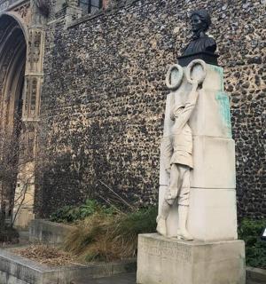 a statue of a man standing in front of a building