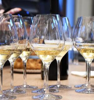 a row of wine glasses with white wine