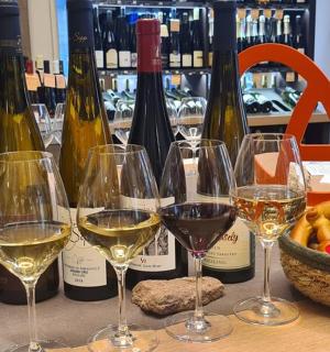 a group of wine glasses on a table with wine bottles