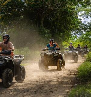 a group of people riding atvs on a dirt road