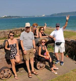 a group of people posing for a picture next to the ocean