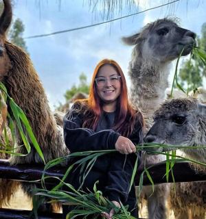 Žena s rudými vlasy krmí nějaká zvířata