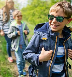 一个小男孩在小路上行走时竖起了大拇指