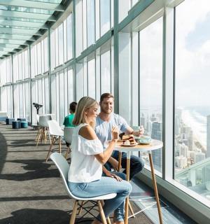 a man and woman sitting at a table in a building with windows