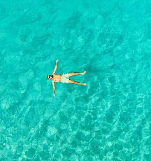 a person is swimming in the blue water