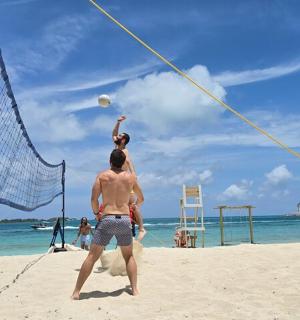a group of people playing volleyball on the beach