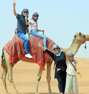 一群人骑着骆驼穿越沙漠
