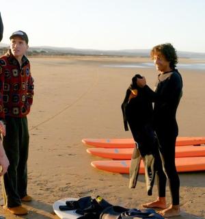 a group of people standing on a beach with surfboards