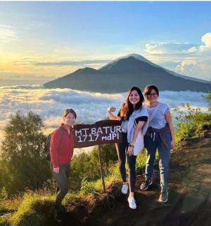 grupa ljudi stoji pored znaka na planini