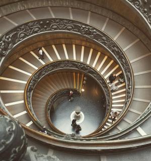 一名男子正在从建筑物内的螺旋楼梯上走下来