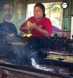 一位女士正在烤架上烹饪食物