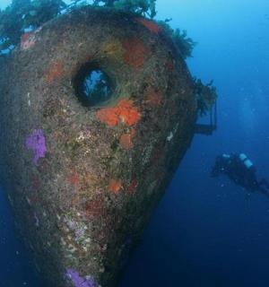 一名潜水员在海中靠近水中的一个大型物体