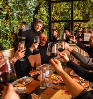 a group of people sitting around a table drinking wine