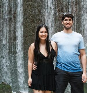 一名男子和一名女子站在瀑布前