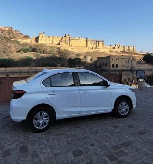 a white car parked on a street with a castle in the background