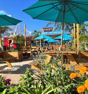 патіо зі столами, парасольками та квітами