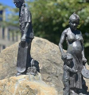 dvě sochy chlapce a dívky na skále