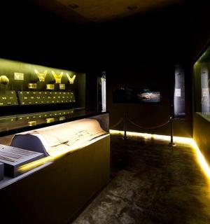 tmavá místnost s vystavenými tenisovými míčky