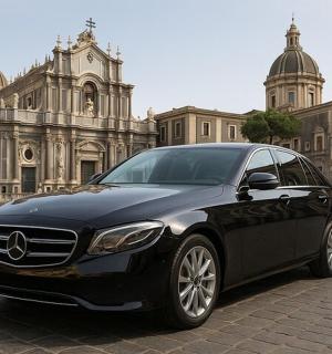 一辆黑色汽车停在一栋建筑物前