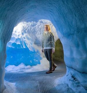 a woman standing inside of an ice cave