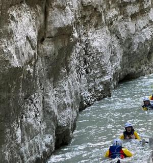 a group of people rafting down a river in a canyon