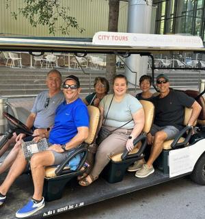 a group of people sitting in a golf cart