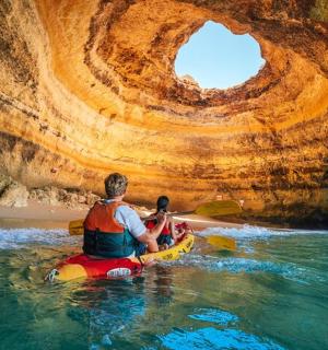 一名男子和一名儿童在洞穴中的皮划艇上