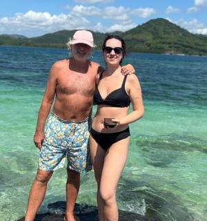 一男一女站在海滩上的水中