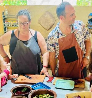 a group of people standing around a table with food