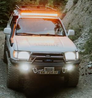 bílý kamion jedoucí po prašné cestě