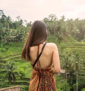 žena stoji na mostu i gleda u polje