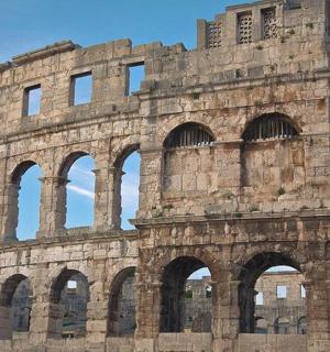 ein großes Gebäude mit Bögen davor