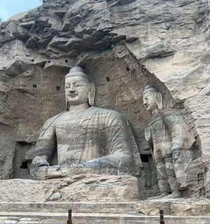 两名男子坐在岩壁上的雕像