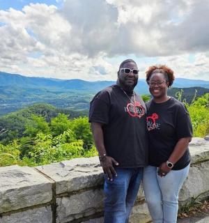 muž a žena stojící na kamenné zdi