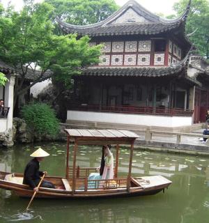 dva lidé v lodi ve vodě před budovou