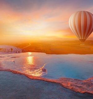 a hot air balloon flying over a body of water