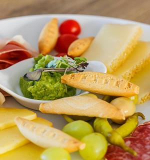 тарілка різних видів сиру та фруктів