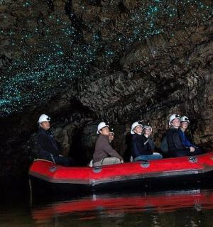 一群人坐在山洞里的红船上