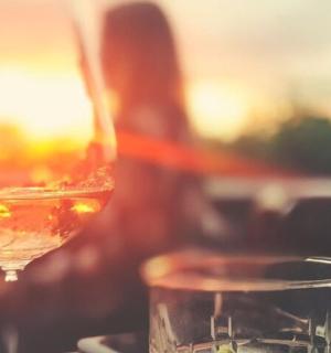 žena stojí vedle sklenice vína