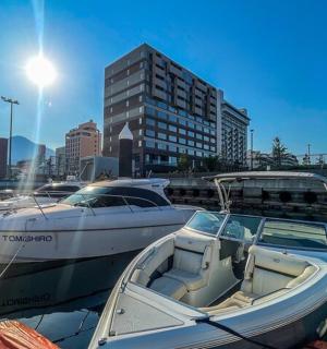 a man standing next to two boats in a marina