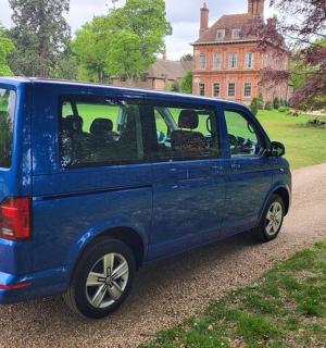 a blue van parked in front of a house