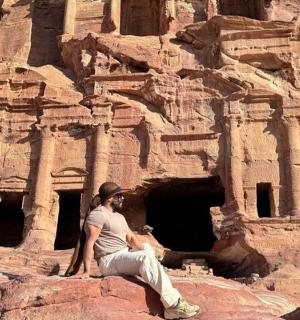 muž sedící na skále před útesem