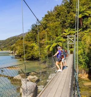 一名男子走过河上的吊桥