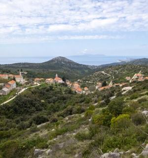 uma pequena cidade em uma colina com montanhas ao fundo