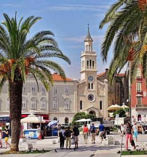 Un gran edificio con una torre de reloj y palmeras.
