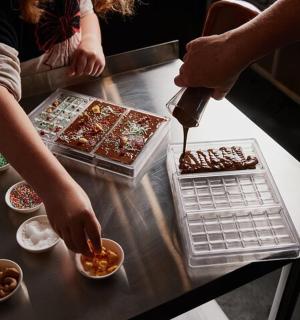 two people preparing food on a counter in a kitchen